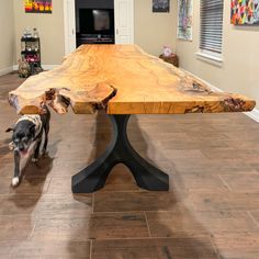 a dog standing next to a large wooden table