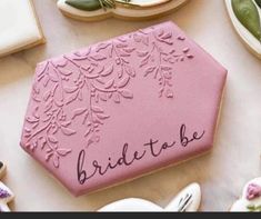 decorated cookies with the word bride to be written on one side and flowers on the other