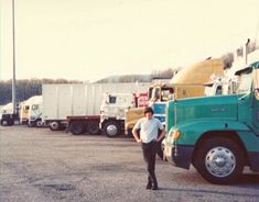 a man standing in front of several semi trucks