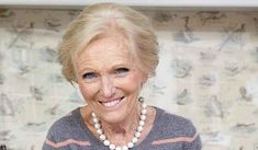 an older woman wearing a necklace and smiling