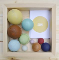 a wooden box filled with lots of different colored balls and a book on top of it