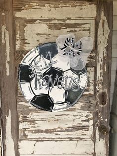 an old door with a soccer ball and flowers on it that says happy new year