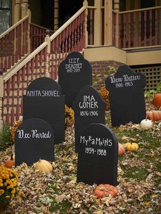 tombstones with names and pumpkins in front of a house decorated for halloween time