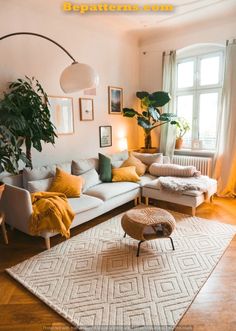 a living room filled with lots of furniture and plants on top of a wooden floor