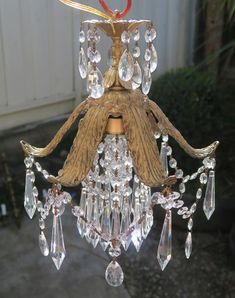 a chandelier hanging from a wooden pole with crystal drops on it's sides