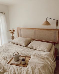 a bed with two pillows and a tea pot on it