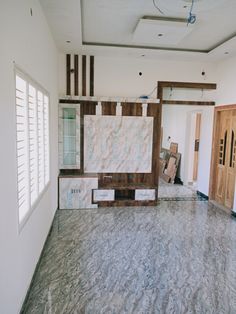 an empty room with marble flooring and wood trimmings on the walls, windows, and doors