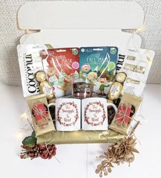 a gift basket filled with coffee, cookies and other holiday treats on a white table