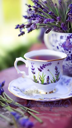 a tea cup and saucer with lavender flowers in it