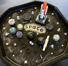 a space themed tray with an assortment of objects on it and the word space spelled out in large letters