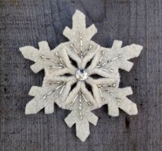 a snowflake made out of white wool on top of a wooden table