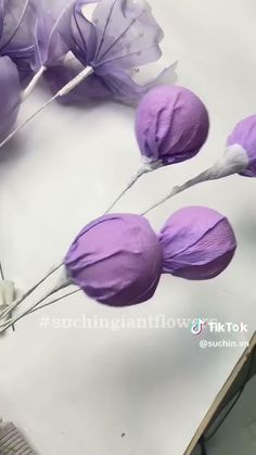 purple paper flowers sitting on top of a table