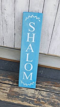 a wooden sign that says shalom on the side of a building with wood planks