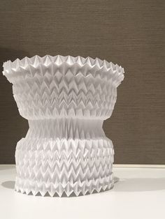 a white vase sitting on top of a table