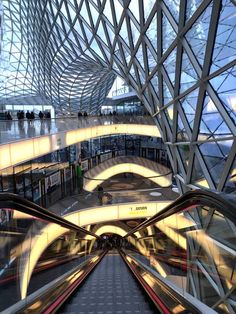 an escalator in the middle of a train station