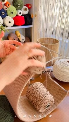 a woman is working with yarn on a table