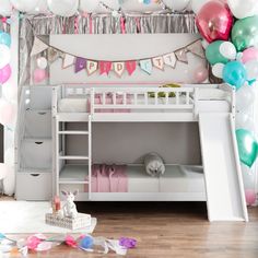 a white bunk bed sitting under a bunch of balloons