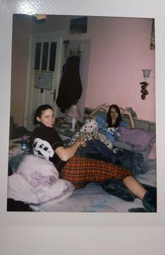 two women laying on a bed with stuffed animals