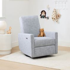 a child's rocking chair with a teddy bear on the armrest in a white room