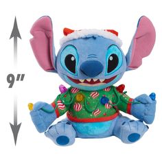 a stuffed animal with an ugly grin on it's face and ears, sitting in front of a ruler