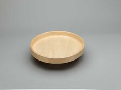 a wooden plate sitting on top of a gray table next to a knife and fork