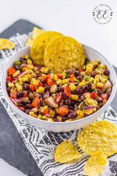 corn and black bean salsa with tortilla chips in a white bowl on a towel