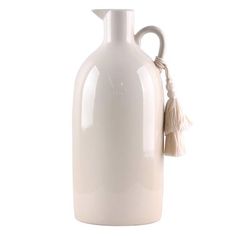 a white ceramic vase with a tasseled handle and handles on the top, is shown against a white background