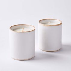 two white candles sitting next to each other