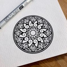 an image of a black and white design on paper with a marker next to it