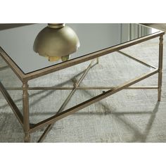 a glass and metal coffee table with a lamp on top