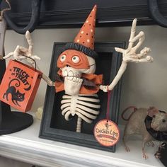 there is a skeleton in a frame with a trick or treat bag hanging from it's side