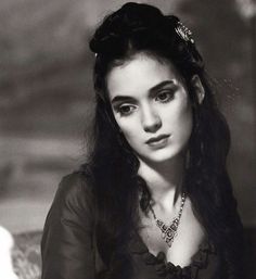 black and white photograph of a woman with long hair wearing a tiara sitting on a couch