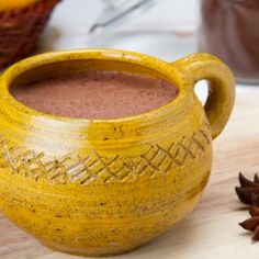 a cup of hot chocolate next to some spices