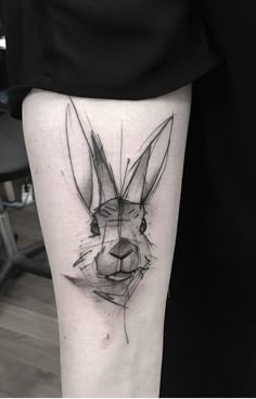 a tattoo on the leg of a person with a rabbit head in black and white