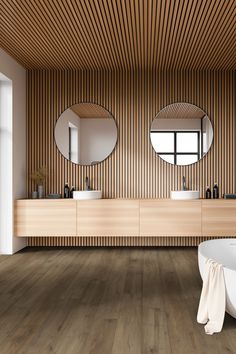 a bathroom with two sinks, mirrors and a tub in the middle of the room