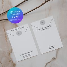 two white paper tags sitting on top of a marble counter