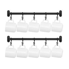 six white mugs hanging from a black rail