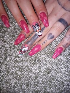 a woman's hand with pink nail polish and cat design on her nails, sitting on carpet