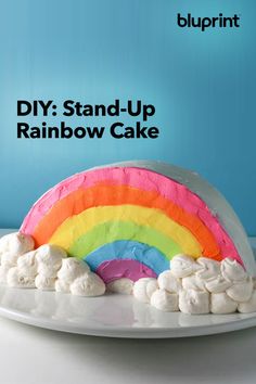 a rainbow cake with marshmallows on it and the words diy stand - up rainbow cake