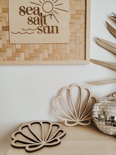 two decorative objects sit on a table next to a mirror ball and bamboo wall art