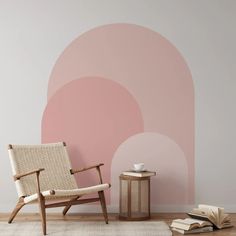 a chair sitting in front of a wall with a pink circle design on the side