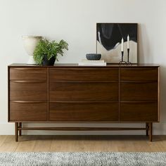 a large wooden dresser sitting on top of a hard wood floor next to a painting