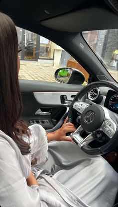 a woman sitting in the driver's seat of a car