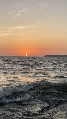 the sun is setting over the ocean with waves