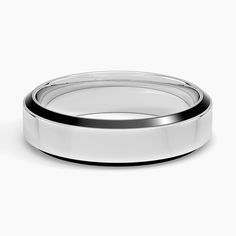 a white wedding band with black edges on a plain surface in front of a white background