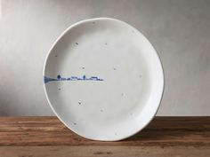 a white plate sitting on top of a wooden table next to a brown countertop