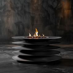 a fire pit sitting on top of a black table next to a dark wall and floor