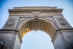 an arch with carvings on it and a blue sky in the background