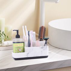 a bathroom counter with soap, toothbrushes and other items