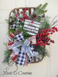 a christmas wreath on the front door with pine cones, berries and evergreens attached to it